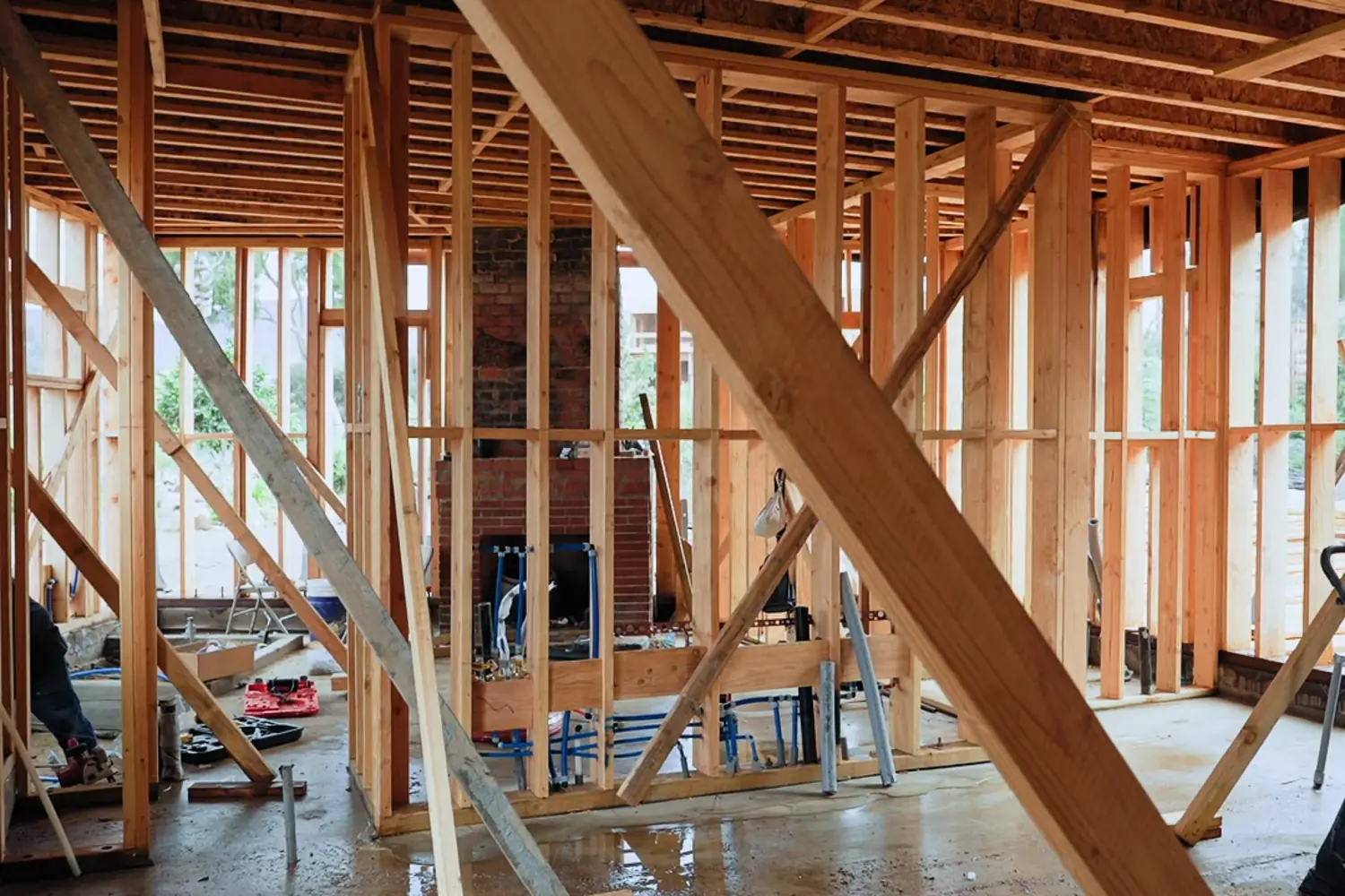 The framed interior of a house under construction, studs and ceiling joists open